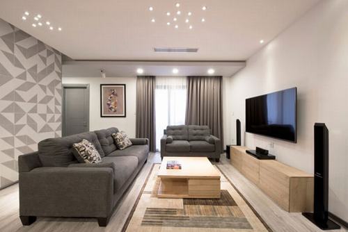 Phòng khách được thiết kế cải tạo căn hộ sang trọng với gam màu trầm