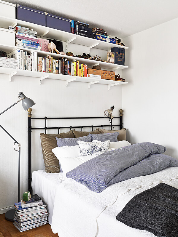 Phòng ngủ trong căn hộ, tối giản đồ đạc rất thông minh: những cuốn tạp chí xếp chồng lên nhau thay cho kệ đầu giường