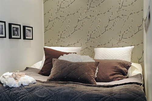 Phòng ngủ nhỏ trong mẫu thiết kế, với tông trắng kết hợp mảng tường hoa văn, ấm cúng cho căn phòng.