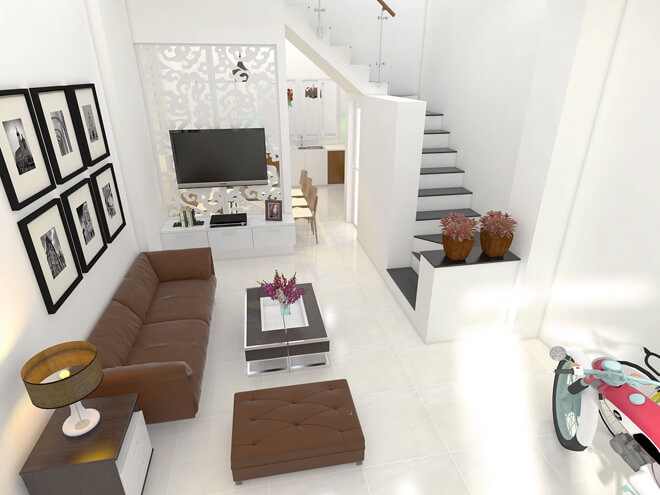 Phòng khách với tone màu trắng chủ đạo làm nổi bật bộ sofa màu nâu, không gian này được trang trí khá đơn giản và nằm liền kề với gian bếp. Tấm vách ngăn cách điệu phân chia hai không gian một cách mềm mại, uyển chuyển trong mẫu thiết kế nhà phố này.