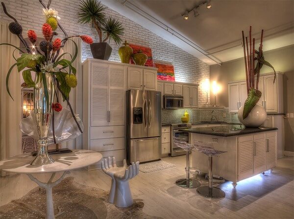 Với thiết kế nội thất nhà bếp đẹp này, các khoảng không phía trên tủ bếp được sử dụng để trang trí và trưng bày, bệ bếp cũng được chiếu sáng bởi một bóng đèn, điểm rất thú vị ở đây là chiếc ghế hình bàn tay.