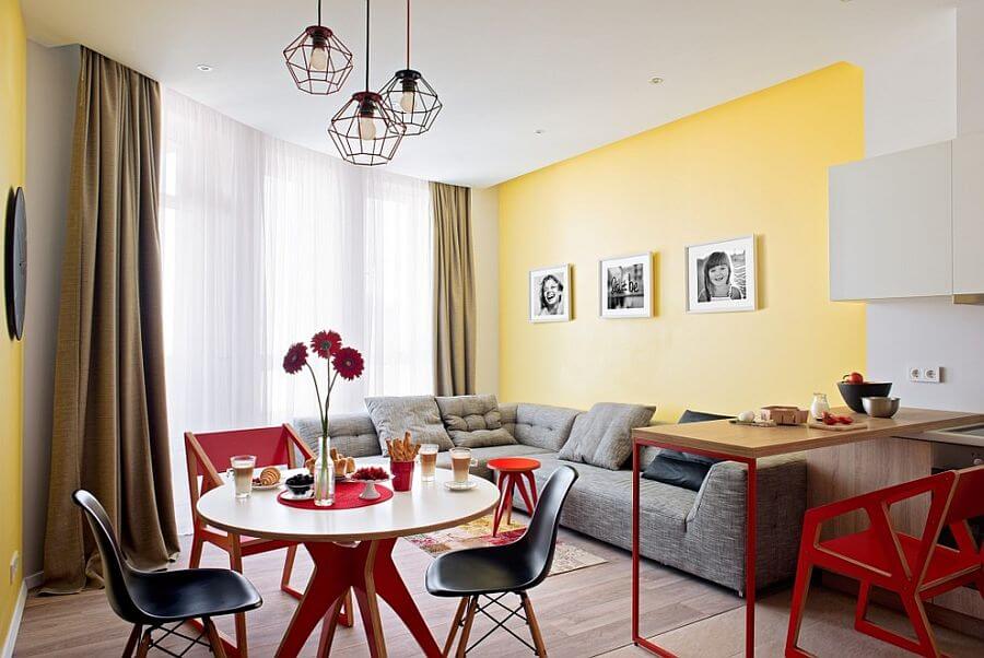 Phòng ăn và phòng khách kết nối mở thông nhau với màu vàng, trắng và màu xám, trong mẫu thiết kế nội thất phòng ăn đẹp này.