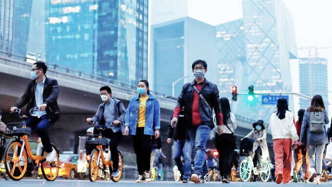 Người dân đi bộ trong giờ cao điểm tại Bắc Kinh. Ảnh: Reuters